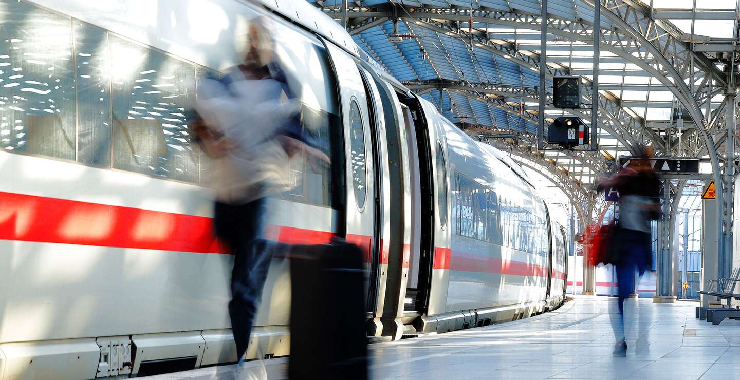 Verschwommene Frau mit Koffer auf dem Bahnsteig mit ICE | © Gettyimages.com/Horst Gerlach