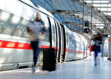 Verschwommene Frau mit Koffer auf dem Bahnsteig mit ICE | © Gettyimages.com/Horst Gerlach