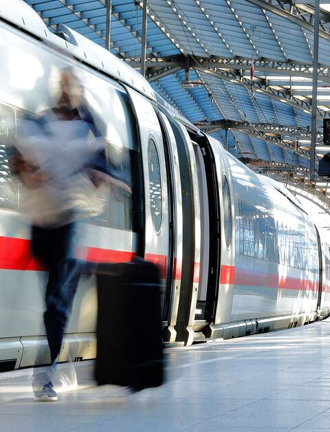 Verschwommene Frau mit Koffer auf dem Bahnsteig mit ICE | © Gettyimages.com/Horst Gerlach