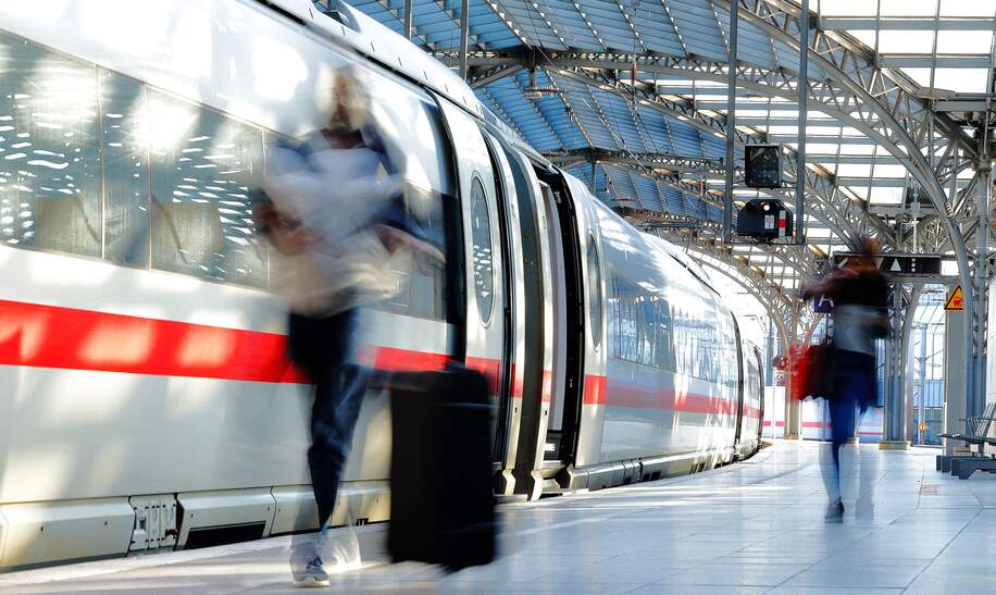 Verschwommene Frau mit Koffer auf dem Bahnsteig mit ICE | © Gettyimages.com/Horst Gerlach