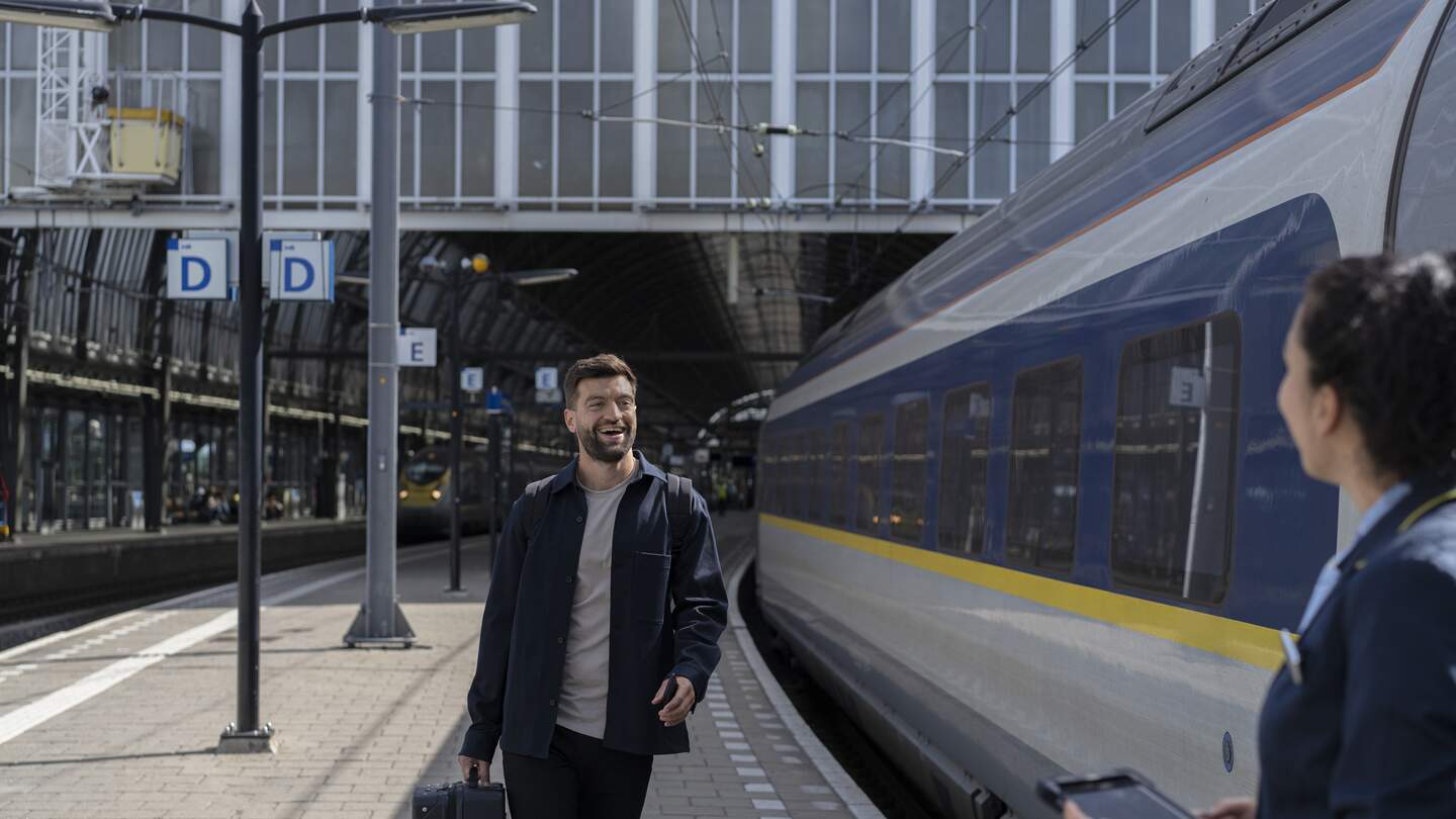 Ein Mann steht am Gleis und steigt in den Eurostar ein | © John Adrian