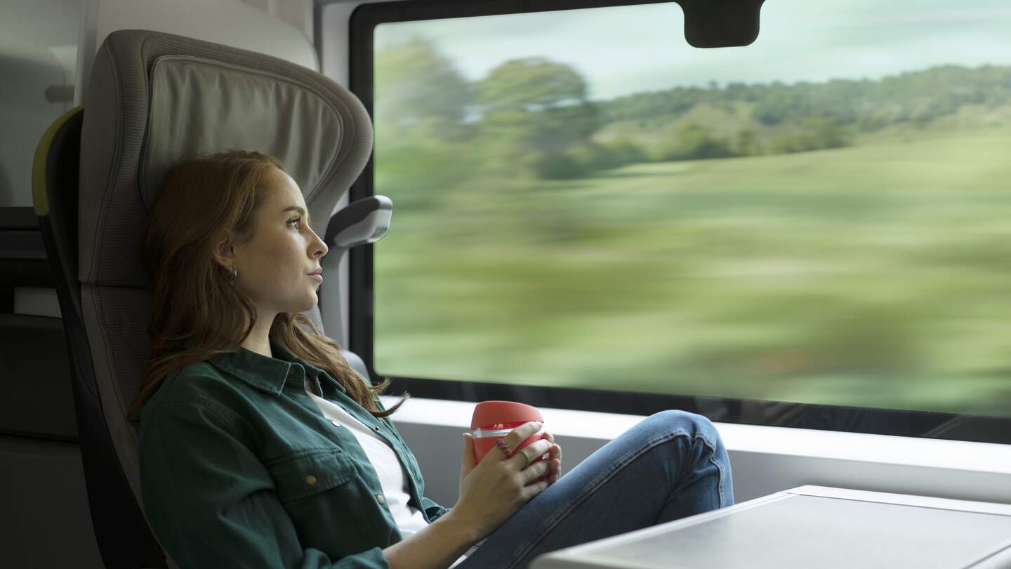 Frau schaut während einer Zugreise aus dem Fenster im Eurostar. | © John Adrian