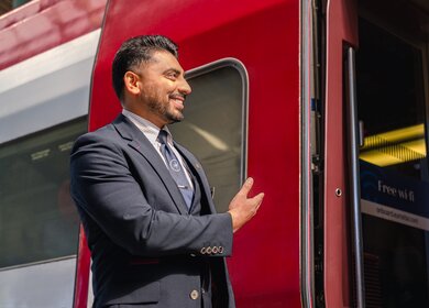 Ein Mitglied des Bordteams lächelt, als es die Fahrgäste im Eurostar begrüßt  im Paris Gare du Nord | © Eurostar