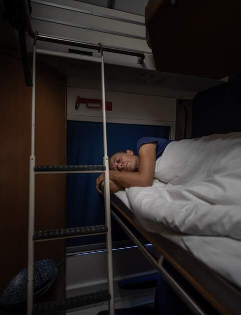 Frau schläft im Schlafwagen eines Nachzugs | © Gettyimages.com/amirphoto