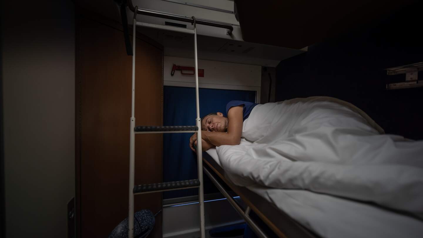 Frau schläft im Schlafwagen eines Nachzugs | © Gettyimages.com/amirphoto
