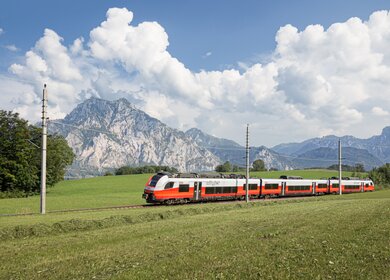 ÖBB Desiro ML Cityjet faehrt ueber eine Wiese mit Bergen im Hintergrund | © ÖBB/Kriechbaum
