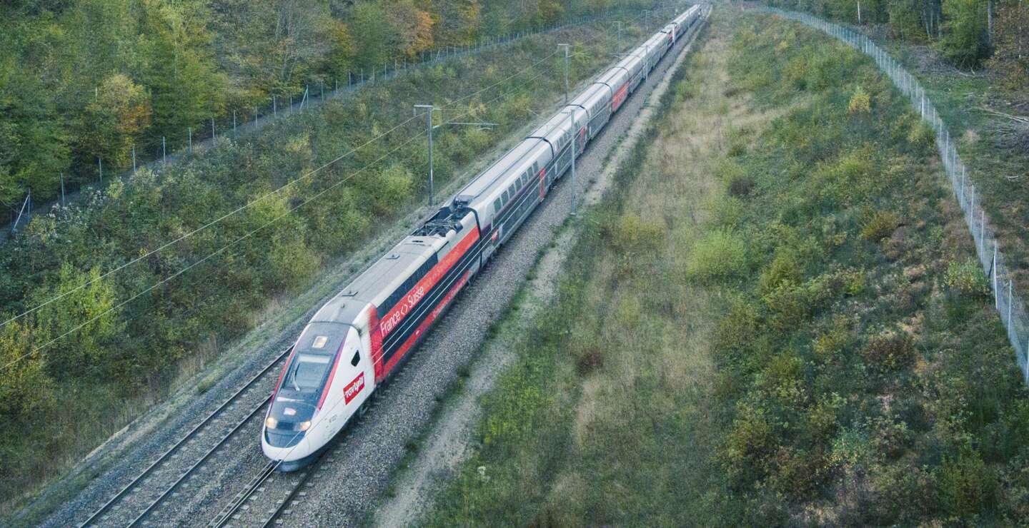 TGV Lyria der SNCF fährt durch eine grüne Landschaft zwischen Frankreich und der Schweiz – komfortable und umweltfreundliche Zugreise | © Olivier Foulon/Groupe SNCF