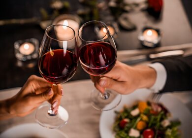 Paar stößt mit Rotwein beim Essen an | © Gettyimages.com/Inside Creative House