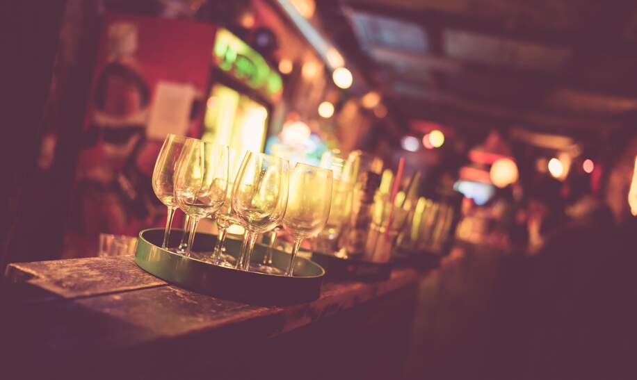 Nahaufnahme von Weinglaesern auf dem tresen einer Ruinenbar in Budapest | © Gettyimages.com/OliverHuitson