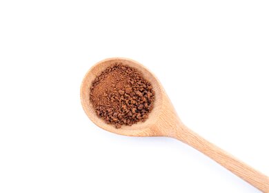 Kakaopulver im Holzlöffel isoliert auf weißem Hintergrund | © Gettyimages.com/Everyday better to do everything you love