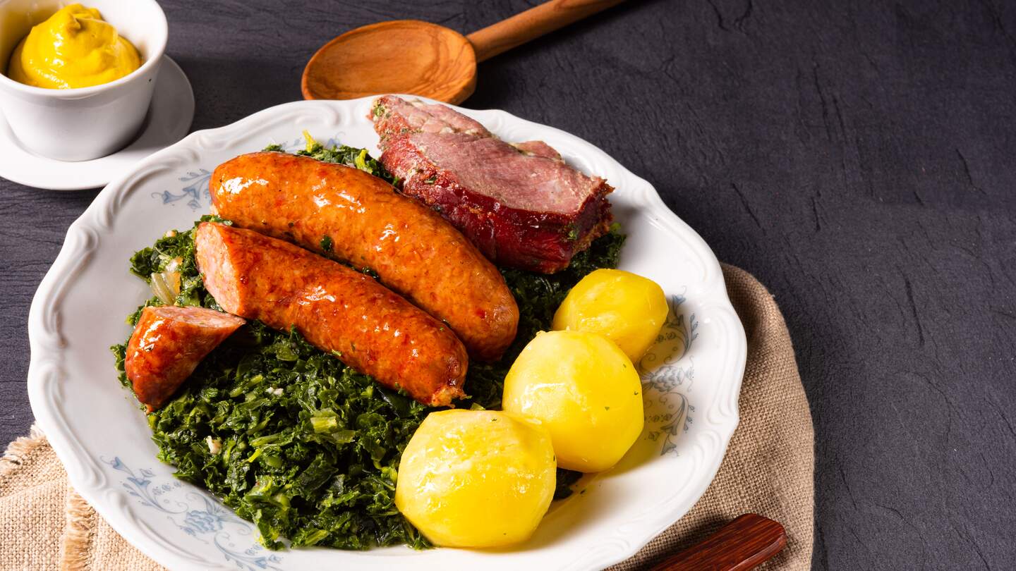 Oldenburger Gruenkohl mit Pinkelwurst, Kassler und Kartoffeln auf einem Teller | © Gettyimages.com/Dar1930
