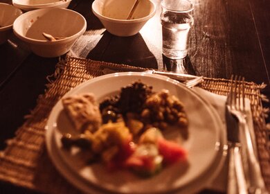 Essen bei Kerzenschein bei romatischer Atmoshaere | © Gettyimages.com/franckreporter