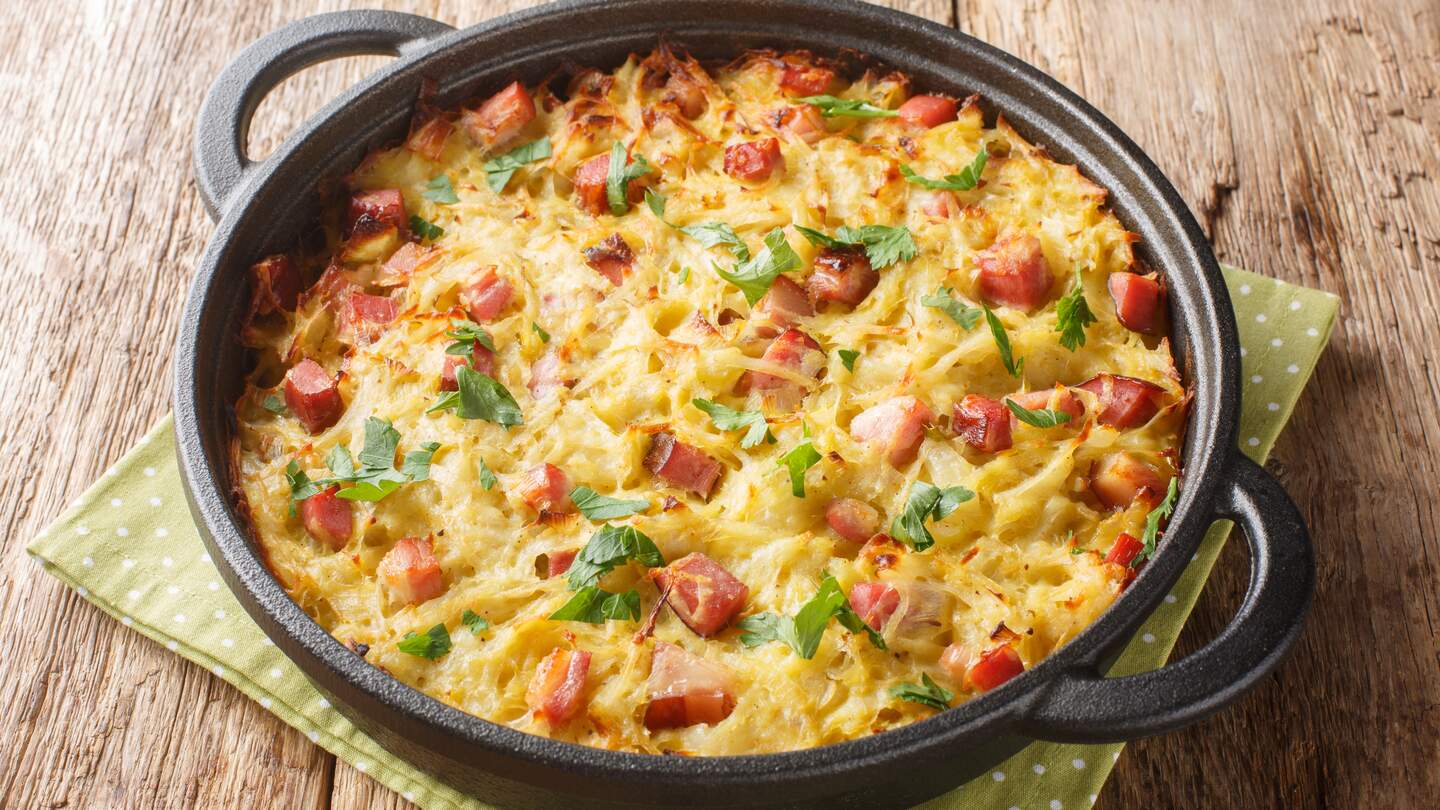 Saarlaendische Hausmannskost: Roesti aus geriebenen Kartoffeln, Lauch, Eiern und gewuerfeltem geräuchertem Speck in Nahaufnahme in einer Pfanne | © Gettyimages.com/ALLEKO