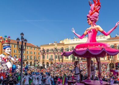 Carnaval de Nice mit dem Thema Koenig des Kinos - Tanzende Ballerina-Wagen blickt mit Hunderten von Menschen im Publikum auf den Koenig des Karnevals zurueck | © Gettyimages.com/Michelle Silke