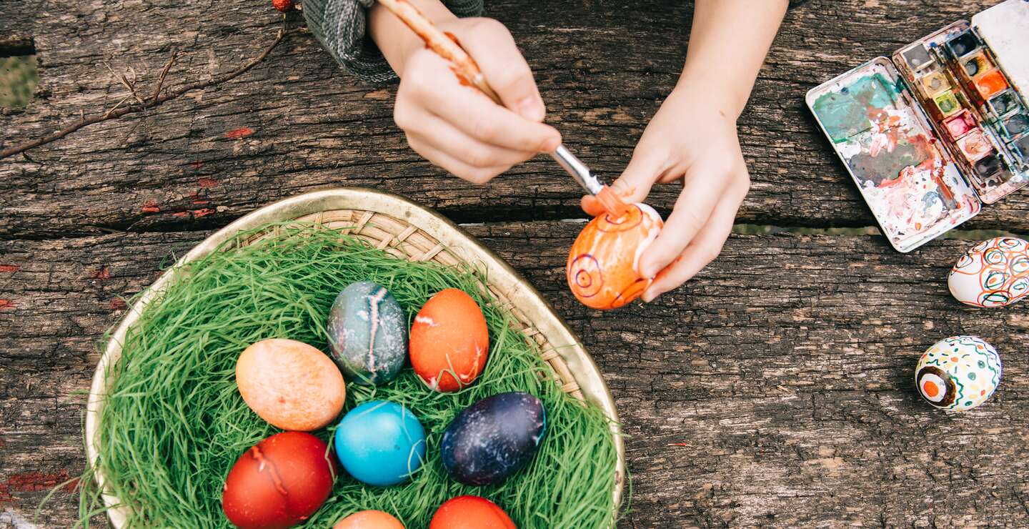 Ansicht von oben auf handbemalte Ostereier auf altem Holztisch mit roter Wasserfarbe | ©  Gettyimages.com/golero
