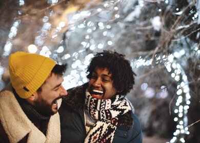 junge maennliche Freunde, die sich in der Silvesternacht im Freien umarmen und lachen. | © Gettyimages.com/Aja Koska