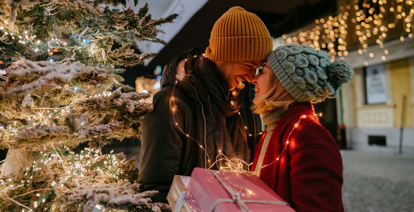 Foto eines romantischen Paares mit Weihnachtsgeschenken im Freien | © Gettyimages.com/AleksandarNakic