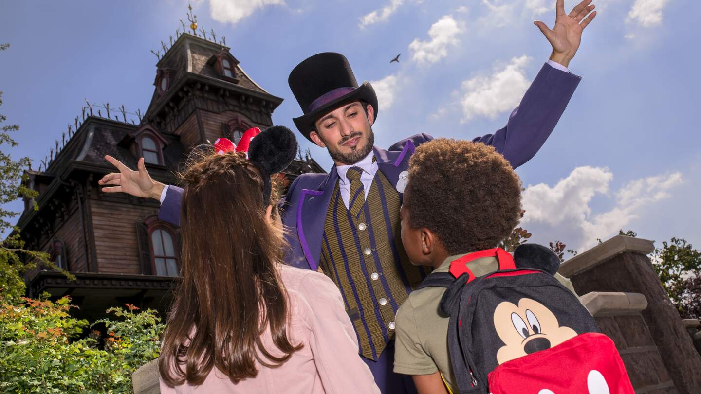 Cast Member und Kinder vor der Attraktion Phantom Manor in Disneyland Park | © Disney