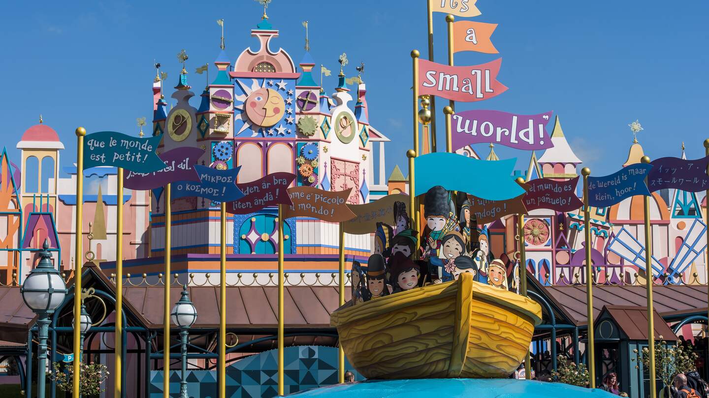 Eingang zur Attraktion Small World in Disneyland  Park mit Fahnen und Boot | © Disney