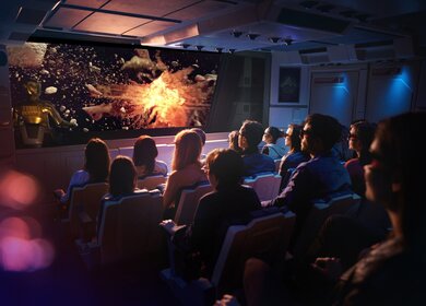 Die Attraktion Star Tours in Disneyland Paris von innen, Personen schauen auf einen Bildschirm und tragen 3D Brillen | ©  Disney  & TM 2024 Lucasfilm Ltd.