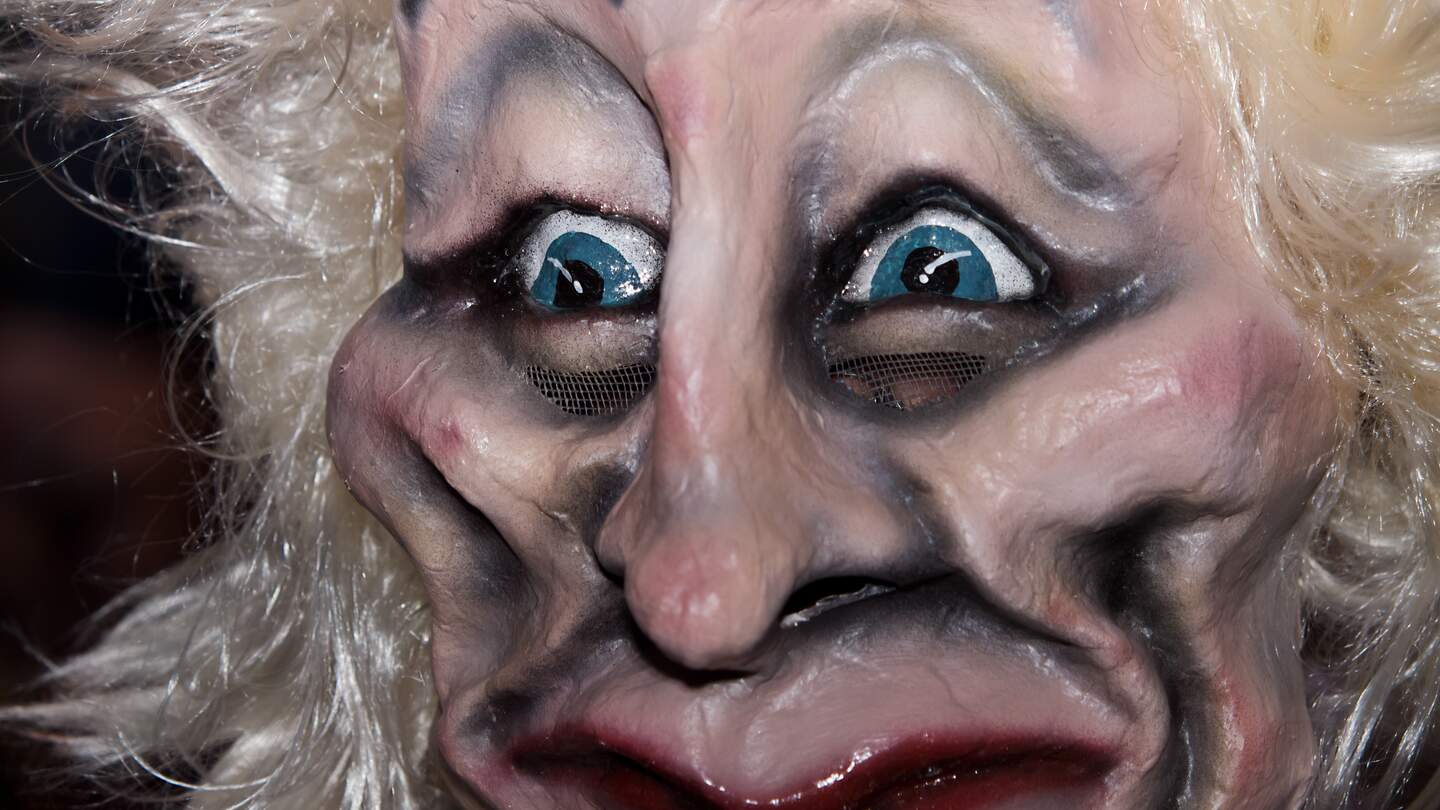 Eine gruslige Faschingsmaske mit wirren weißen Haaren von der Luzerner Fasenacht in Großaufnahme | © GettyImages.com/scubaluna