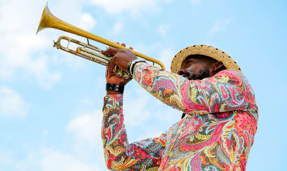 Kubanischer Musiker im bunten Hemd mit Trompete gegen blauen Himmel, Havanna, Kuba | © Gettyimages.com/Bim