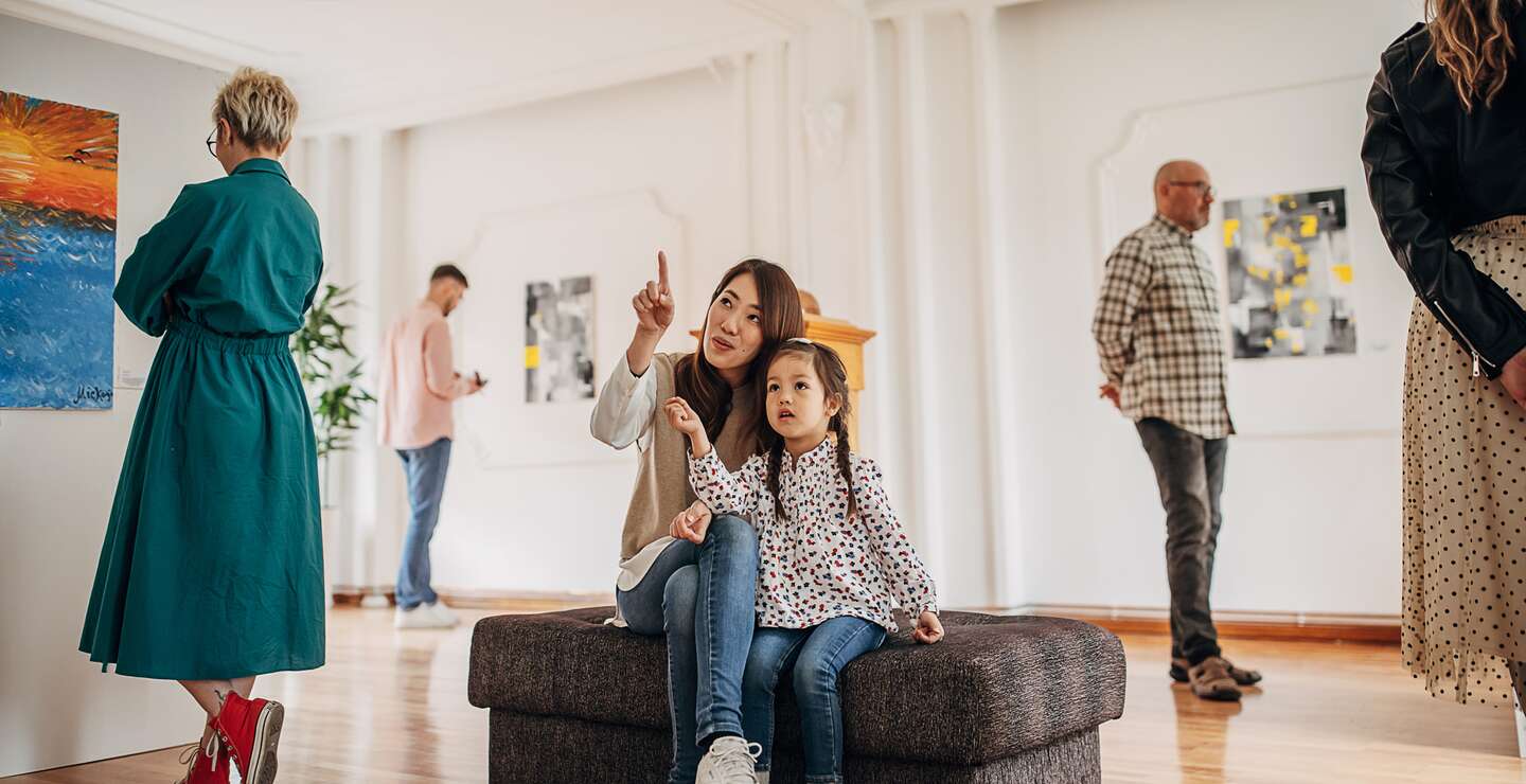 Vielfaeltige Besuchergruppe in der Galerie fuer moderne Kunst, die Gemaelde betrachtet. Mutter brachte ihre Tochter mit. Mutter und Tochter in der Kunstgalerie | © Gettyimages.com/South_agency