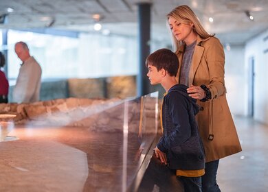 Eine Mutter besucht ein Museum mit ihrem kleinen Sohn an einem Wochenende | © Gettyimages.com/AzmanJaka