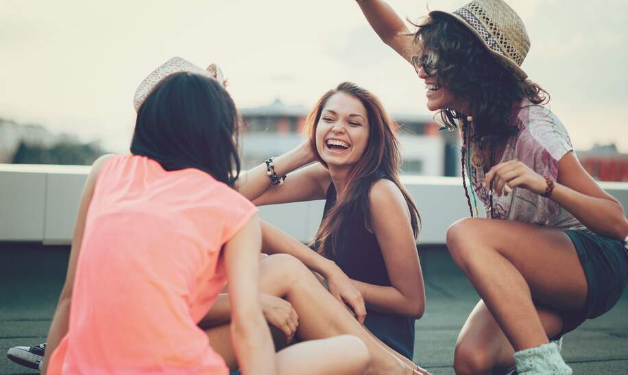 Drei Fraundinnen haben Spass auf dem Dach eines Hauses | © Gettyimages.com/pixelfit