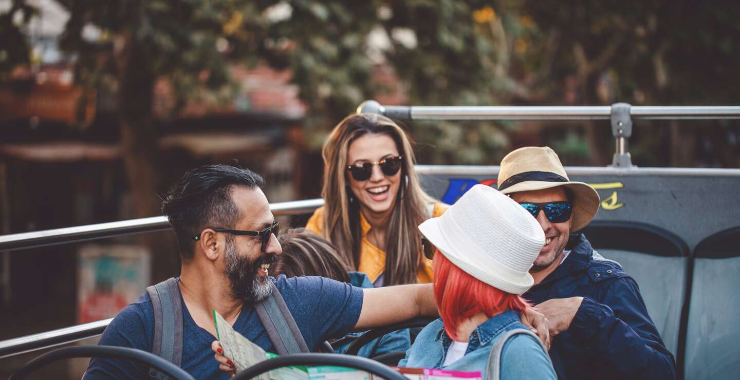 Touristen, die die Stadt in einem Reisebus erkunden | © Gettyimages.com/FluxFactory