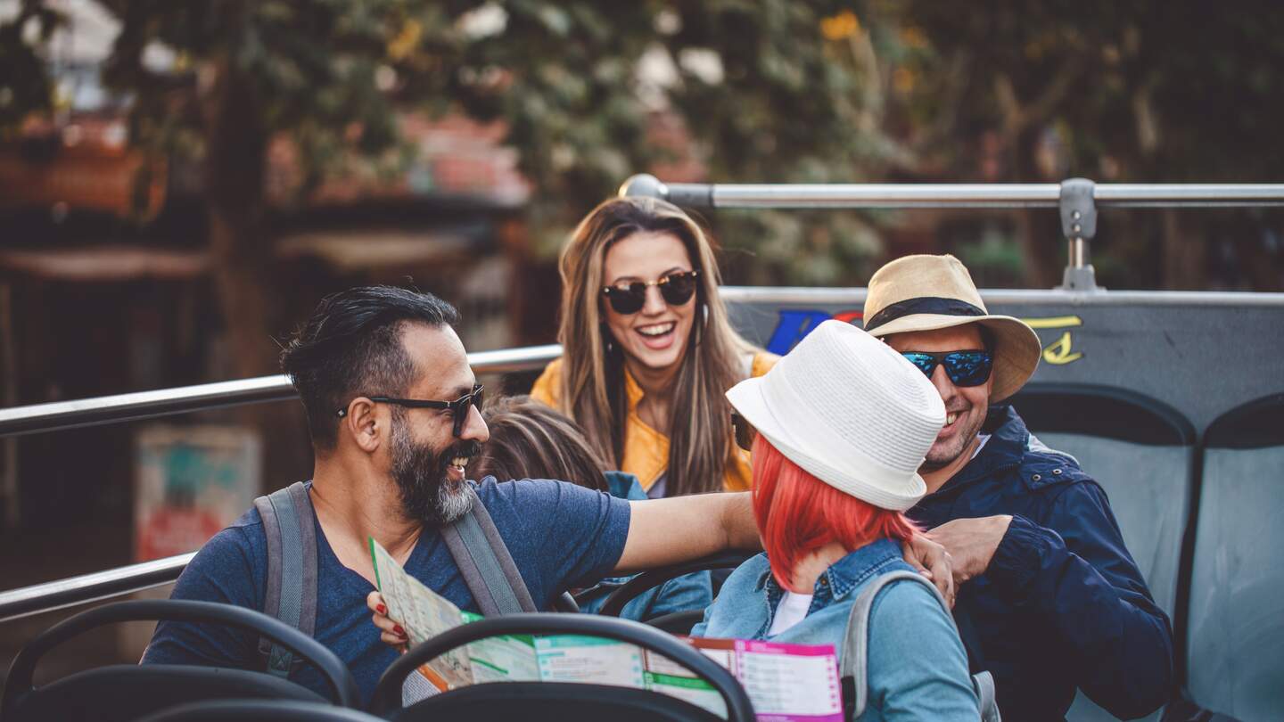 Touristen, die die Stadt in einem Reisebus erkunden | © Gettyimages.com/FluxFactory