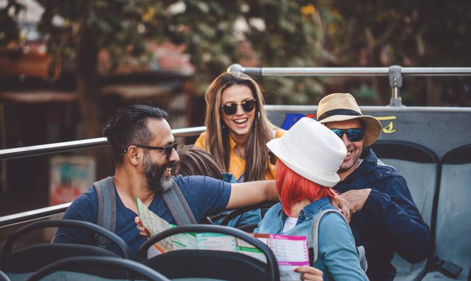 Touristen, die die Stadt in einem Reisebus erkunden | © Gettyimages.com/FluxFactory