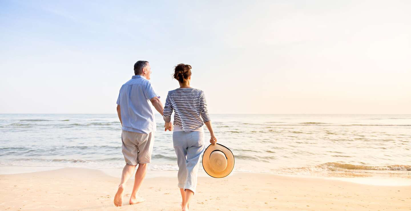 Aktives Seniorenpaar, das am Strand spazieren geht | © Gettyimages.com/FredFroese