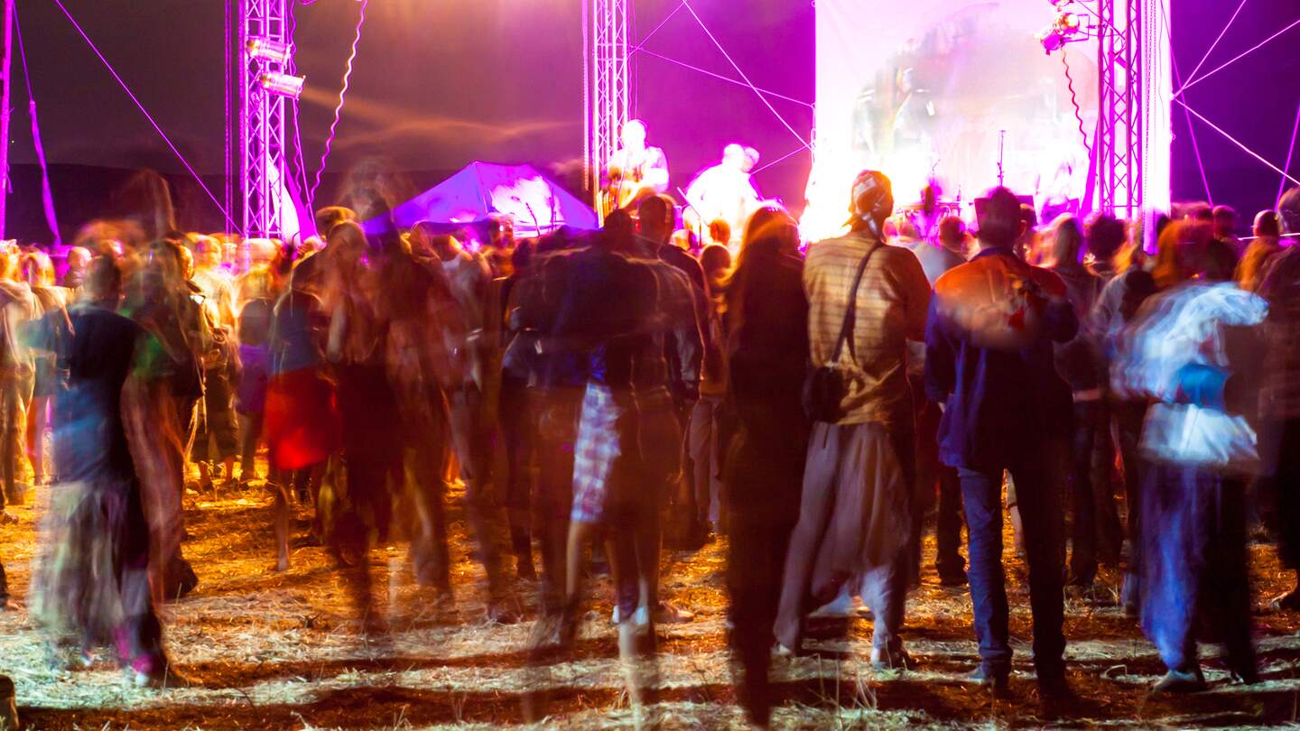 Freiluftkonzert hell und laut, lila Licht auf der Buehne | © Gettyimages.com/wassilly