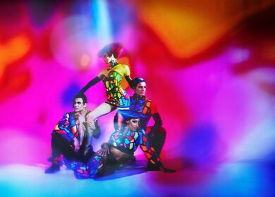 Vier Schauspieler stehen im Opening-Act in bunten Kostümen auf der Bühne. | © Kristian Schuller