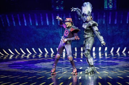 Szenenbild mit Irra Cenina als E-Lok Elecrta und Daniel Ellison als Bremswagen Caboose aus dem Musical Starlight Express | © Starlight Express/Detlef Overmann