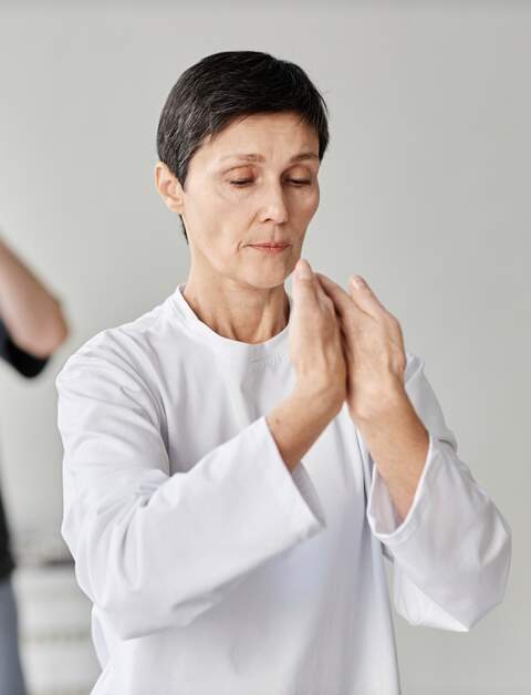 Bruenette aeltere kaukasische Dame konzentriert sich auf Qigong-Uebung | © gettyimages.com/SeventyFour