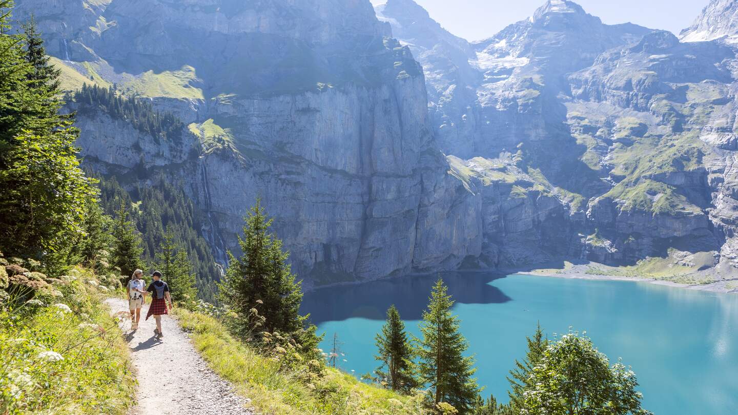 Zwei Personen wandern im Sommer in einer wunderschoenen Alpenlandschaft in den Schweizer Alpen | © Gettyimages.com/Mystockimages