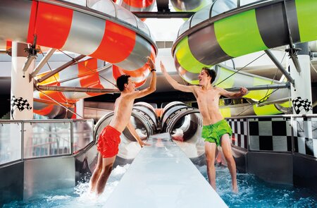 2 Jungs klatschen sich ab vor der Speedracer Rutsche in der Therme Erding | © VRENI ARBES