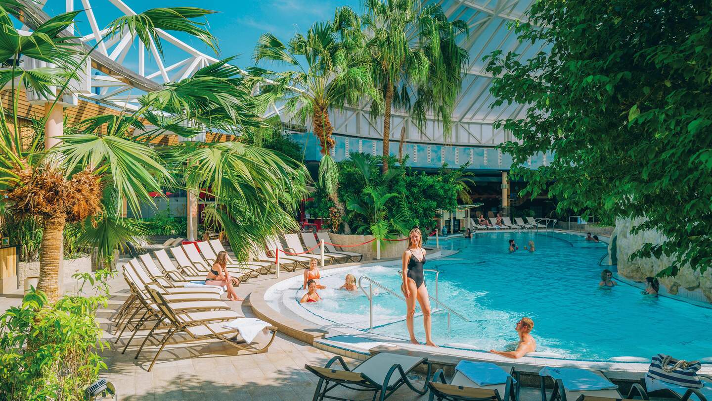 Menschen im und um den Vitalpool mit vielen Sonnenliegen | © THERME ERDING