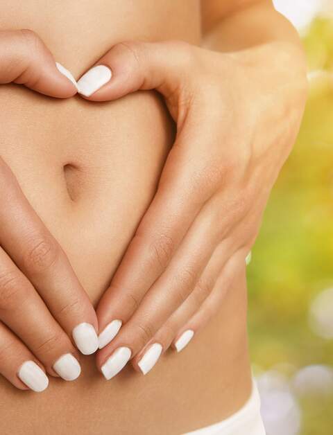 Diätkonzept, weibliche Hände formen Herzform auf dem Bauch | © Gettyimages.com/Nastco