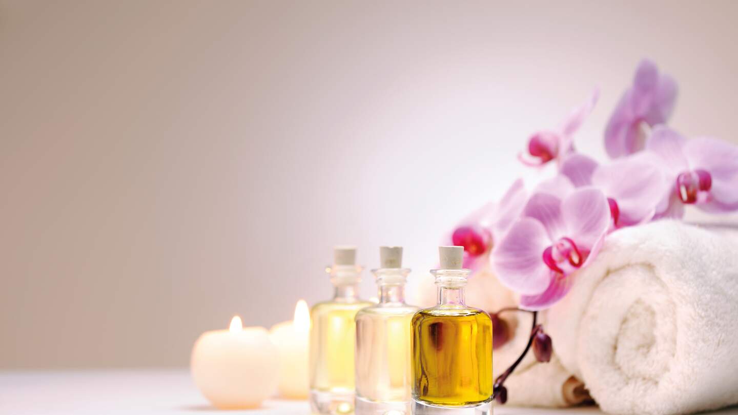 Handtuecher, Orchideen, Kerzen und Oele vor weissem Hintergrund | © Gettyimages.com/Moncherie