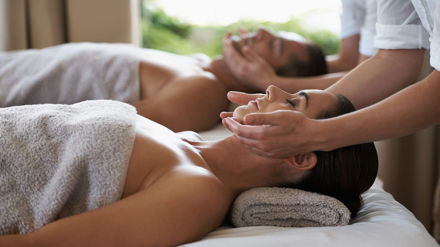 Aufnahme eines Paares, das eine entspannende Massage geniesst | © Gettyimages.com/PeopleImages