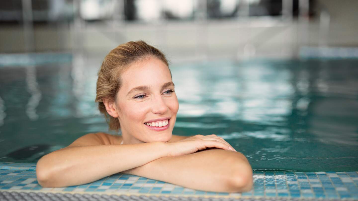 Eine Frau gentspannt sich im Pool | © Gettyimages.com/nd3000