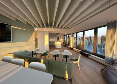 Gemeinschaftsbereich Ameropa mit meheren Tischen und Stuehlen sowie Zugang zur Dachterrasse | © Ameropa/Verena Cezanne