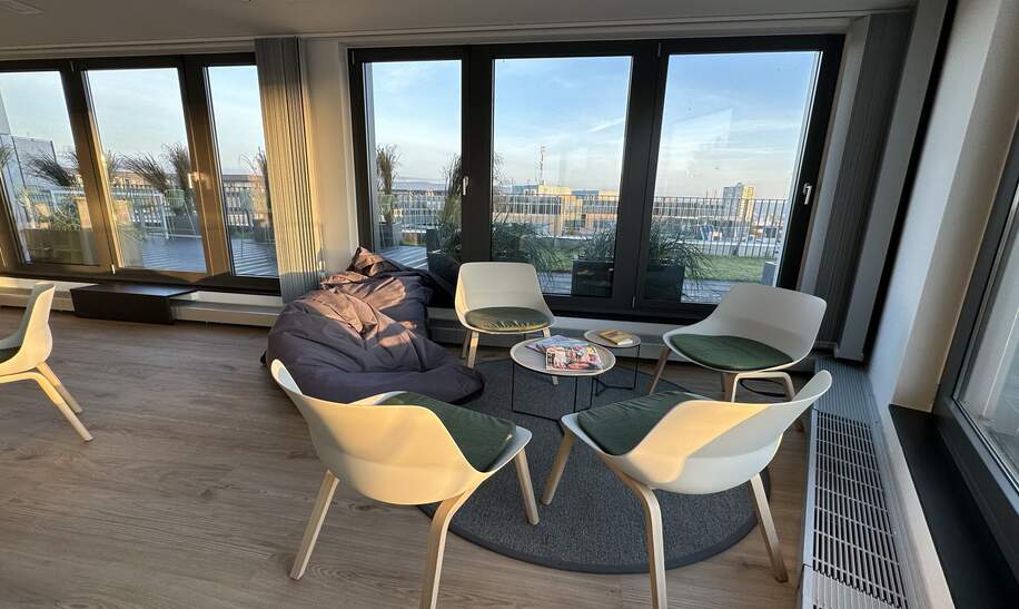 einer Sitzecke aus vier Stuhlen,einem Sofa und grossen Kissen und einem runden Tisch besteht.  | © Ameropa Reisen