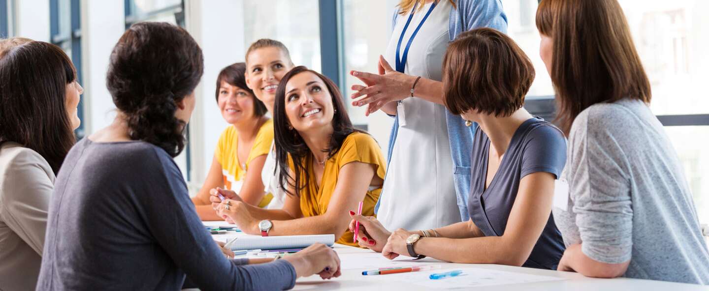 ruppe von Frauen, die an einer Schulung teilnehmen, zusammenarbeiten und diskutieren | © Gettyimages.com/izusek 