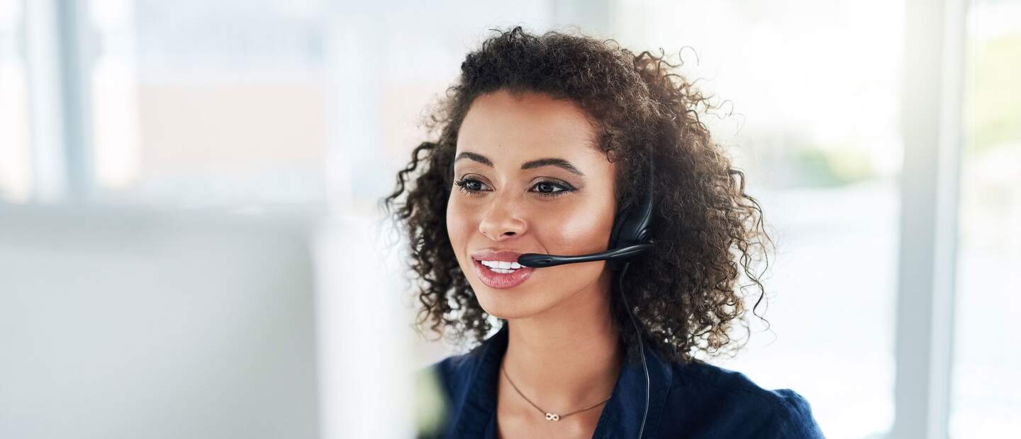 Ausschnitt einer attraktiven jungen Callcenter-Agentin bei der Arbeit in ihrem Buero | © Gettyimages.com/peopleimages