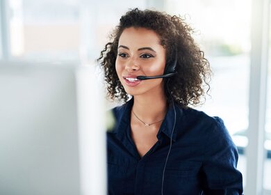 Ausschnitt einer attraktiven jungen Callcenter-Agentin bei der Arbeit in ihrem Buero | © Gettyimages.com/peopleimages