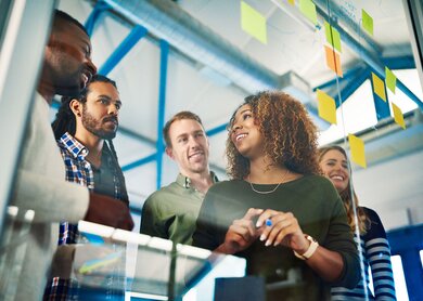 Aufnahme von Kollegen, die eine Brainstorming-Sitzung mit Haftnotizen bei der Arbeit haben | © Gettyimages.com/Peopleimages